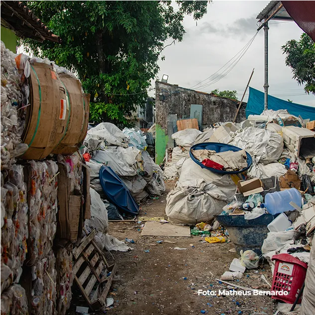 Fardos de material reciclável empilhados na comunidade