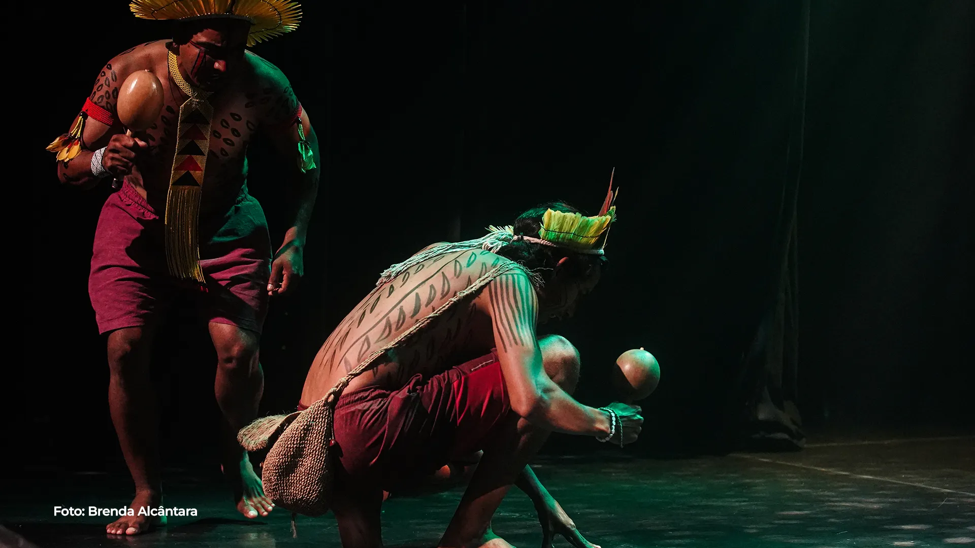 Artistas em cena com figurinos de folhas e sementes